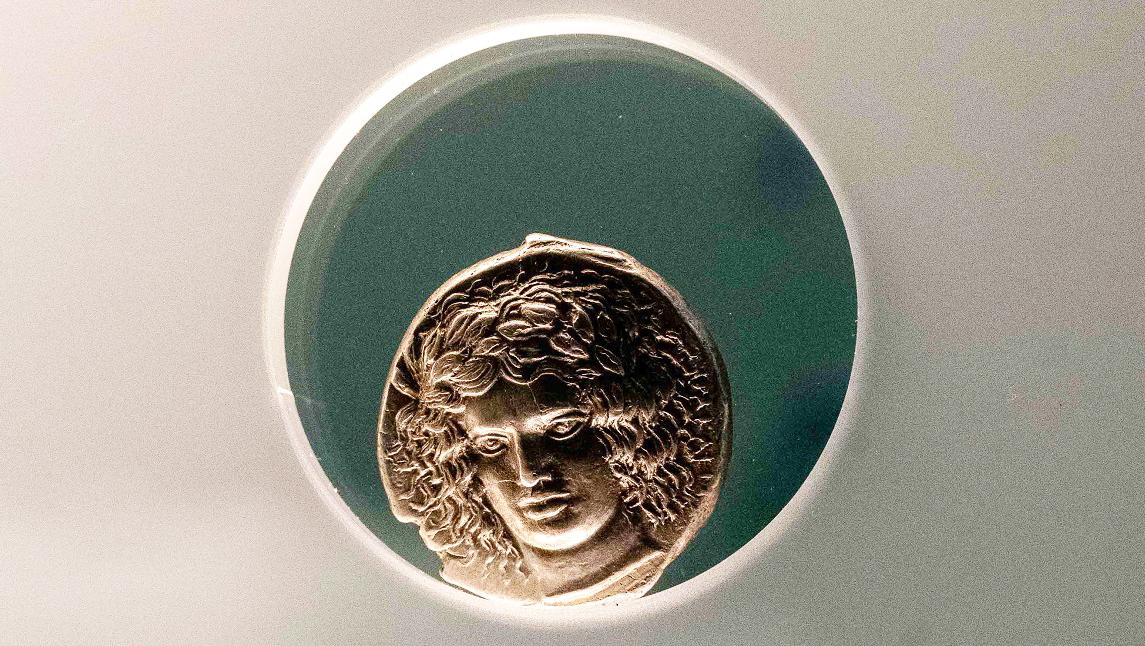 Moeda grega de prata com a figura de Apolo laureado com um farta cabeleira.
