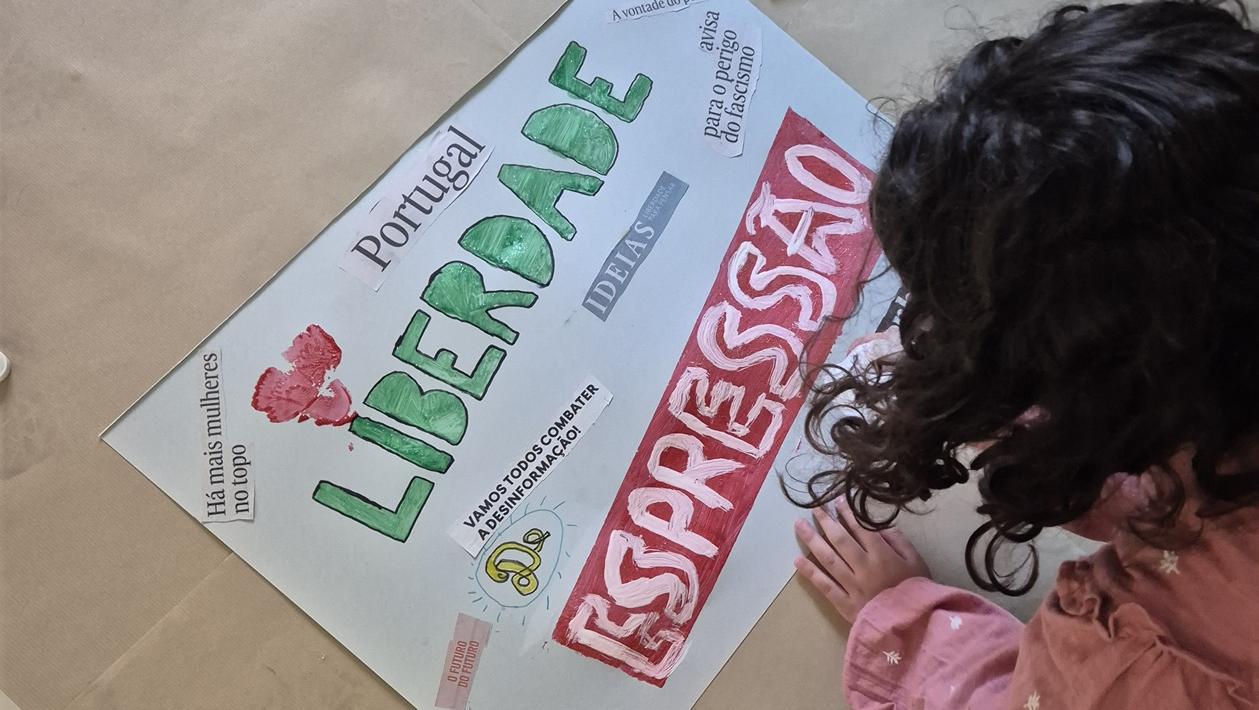 Criança pinta um cartaz