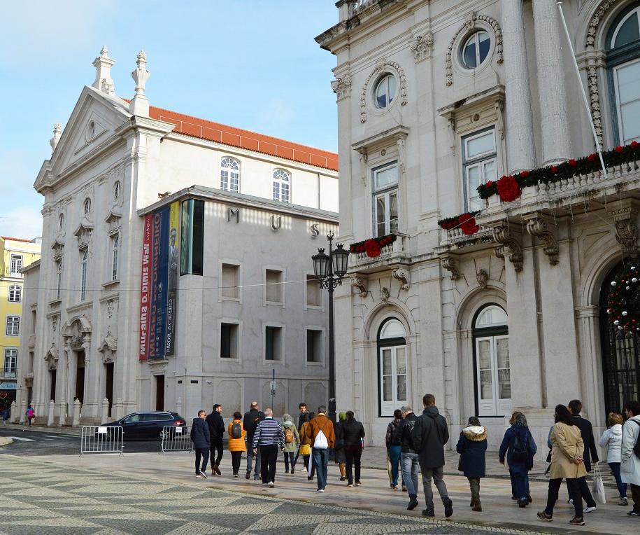 Grupo de pessoas caminha à frente dos Paços do Conselho (Câmara Municipal de Lisboa)